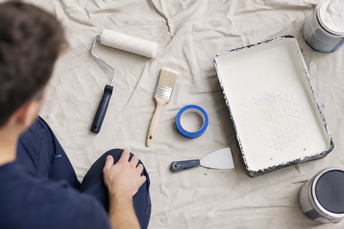 Painting tools laid out on a drop cloth