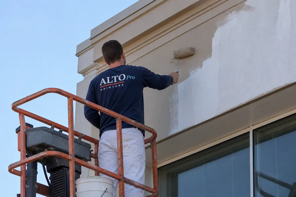 Painter on a lift painting a commercial building, commercial painting in Oliver