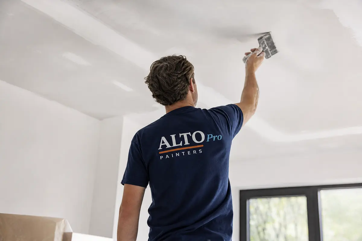 Painter applying joint compound to a ceiling, popcorn ceiling removal in Penticton
