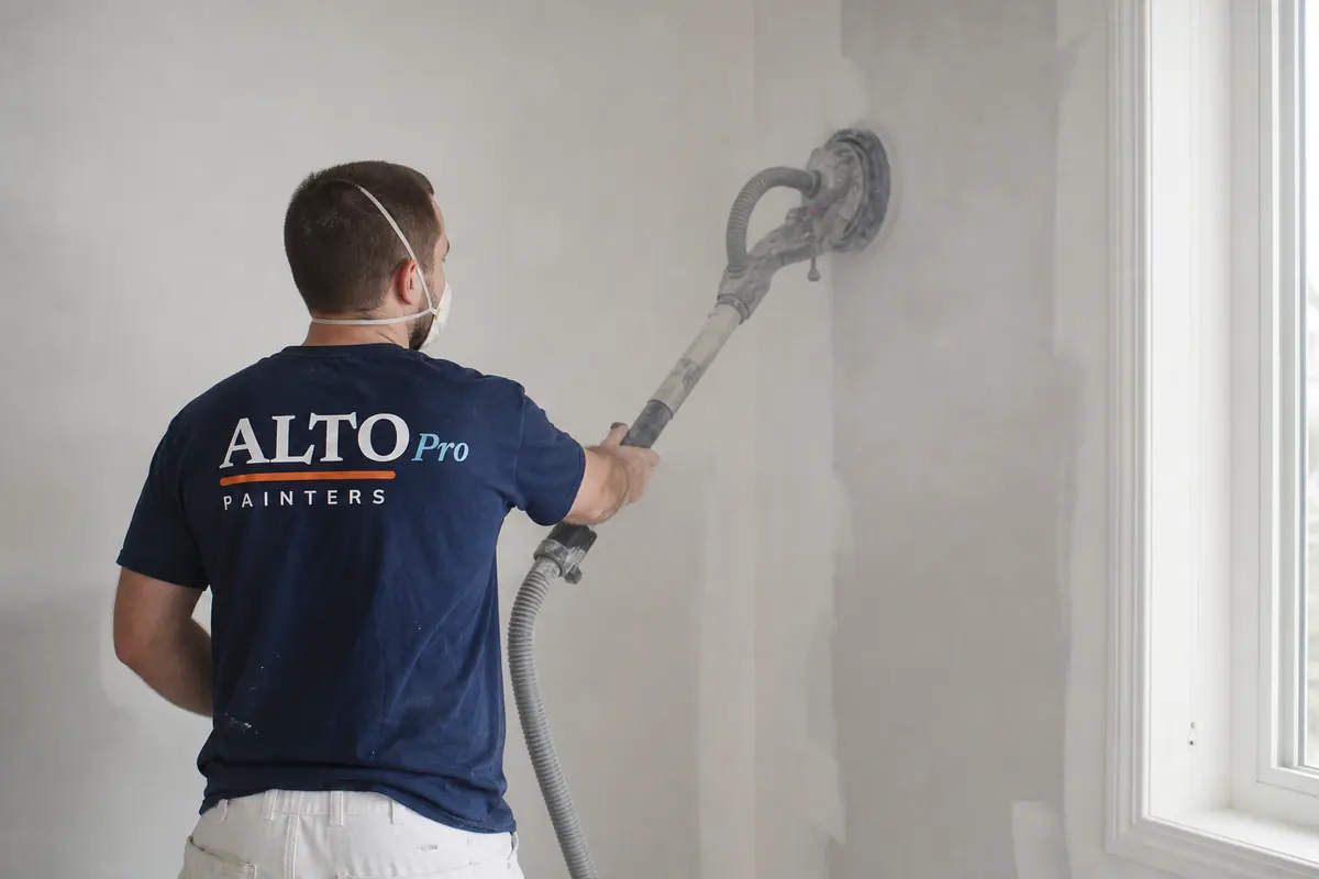 Painter sanding a wall with a pole sander, Alto Pro Painters