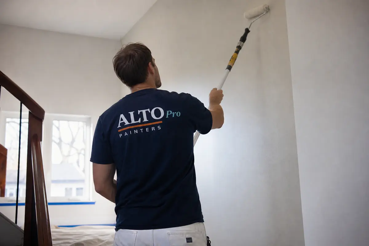 Painter rolling a stairwell wall, interior painting in Osoyoos